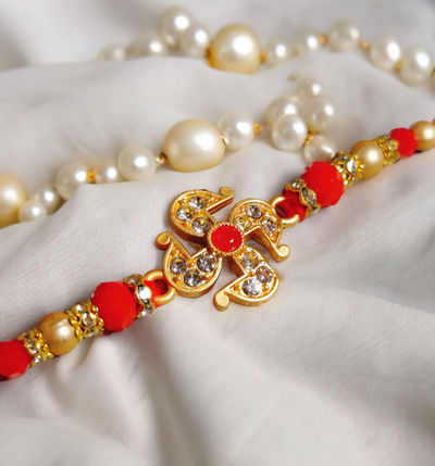 House Of Festivals Designer Swastik Pendant Rakhi with Red Moti - Artistic and Symbolic