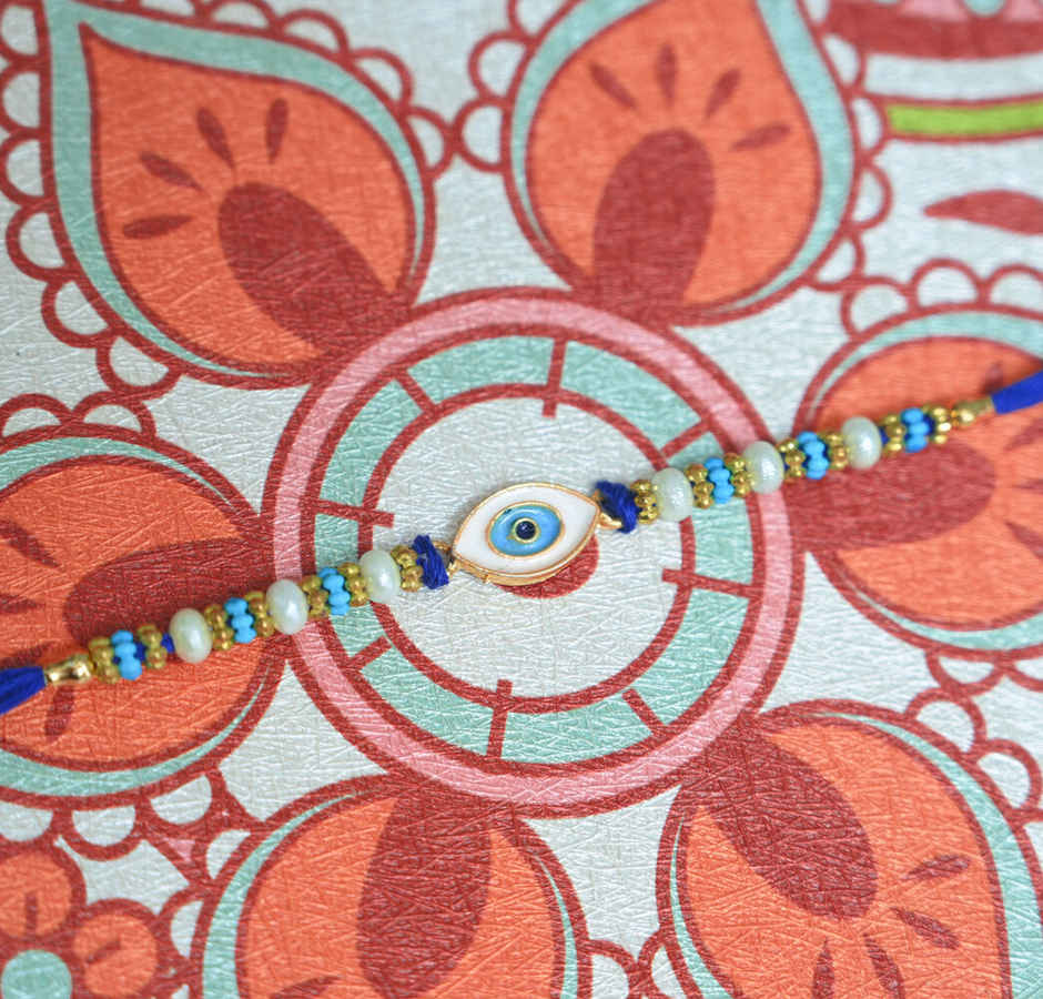 Lindt Lindor Smooth Melting Assorted Chocolates Cornet(200gms) & Aurum Blue Evil Eye Rakhi Multiple Pearls & Beads(1pc) Combo