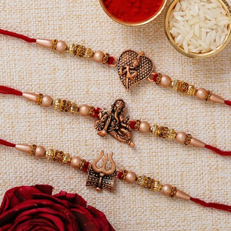 Religious Red & Golden Trishul with Damru, Lord Ganesha, & Lord Krishna Playing Flute Rakhis & Roli Chawal Pack (eCraftIndia) Set of 3