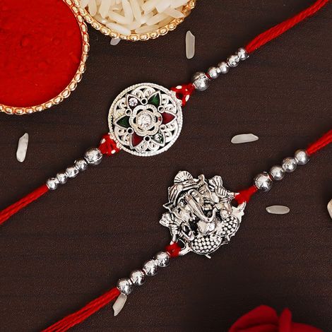 Religious Silver Religious Lord Ganesha and Flower Designer Rakhis with Red Threads, & Roli Chawal Pack (eCraftIndia) Set of 2