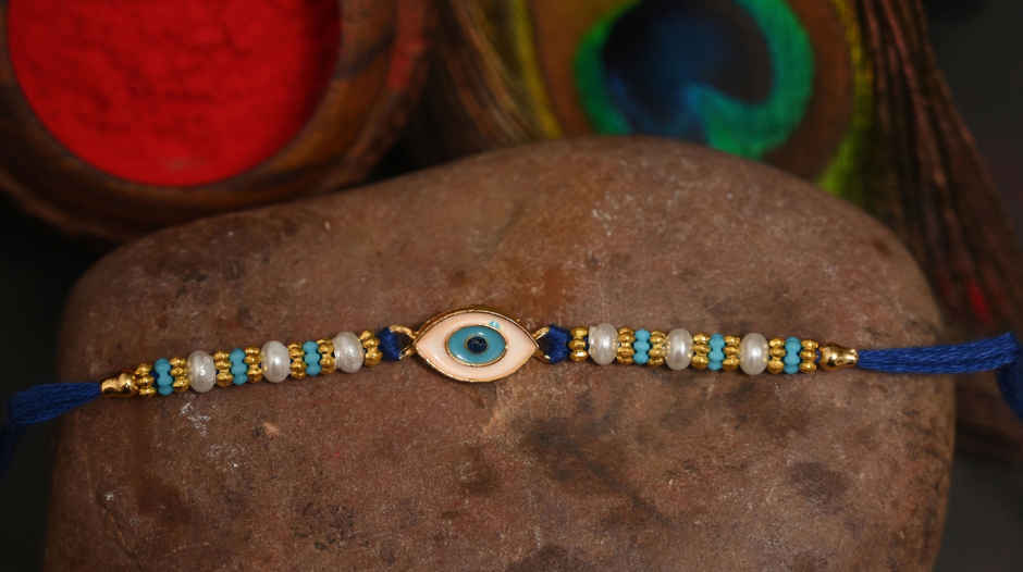 Lindt Lindor Smooth Melting Assorted Chocolates Cornet(200gms) & Aurum Blue Evil Eye Rakhi Multiple Pearls & Beads(1pc) Combo