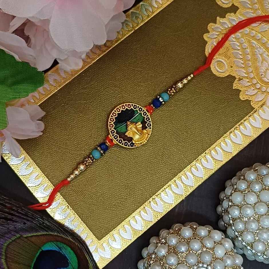 Matt Gold Metal Ganpati Round Frame Peacock Feather Rakhi | Divine and Beautiful | Gullak