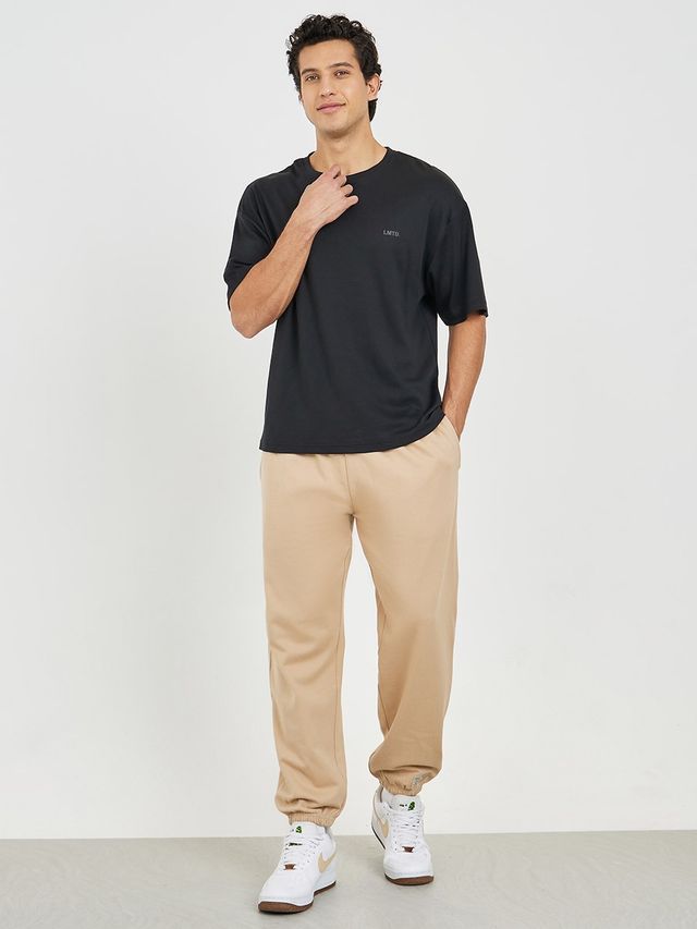 Styli Men's Relaxed Fit Jogger with Zip Pockets and Badge Detail | Beige - L